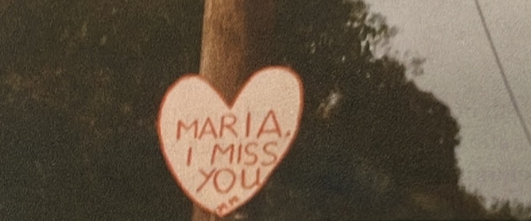 Michael's sign for Maria reading 'Maria, I miss you'
