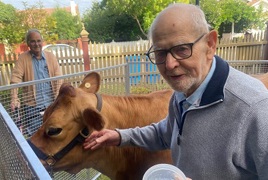 Haydn James resident with milking cow