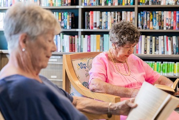 Two elderly females reading peacefully 