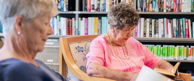 Two elderly females reading peacefully 